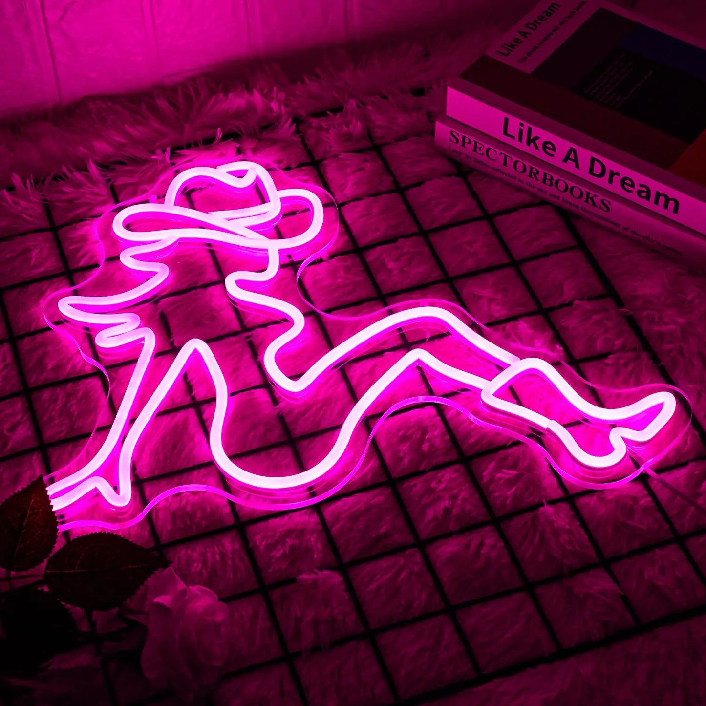 Cowgirl neon sign close-up showing vibrant pink glow with bold western silhouette design in dark ambient setting