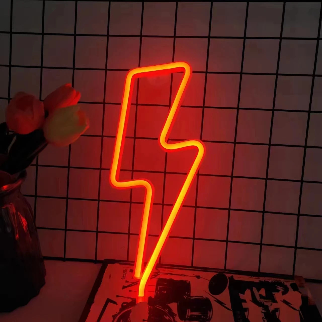 Lightning bolt neon sign in red featuring bold orange-red glow on brick wall