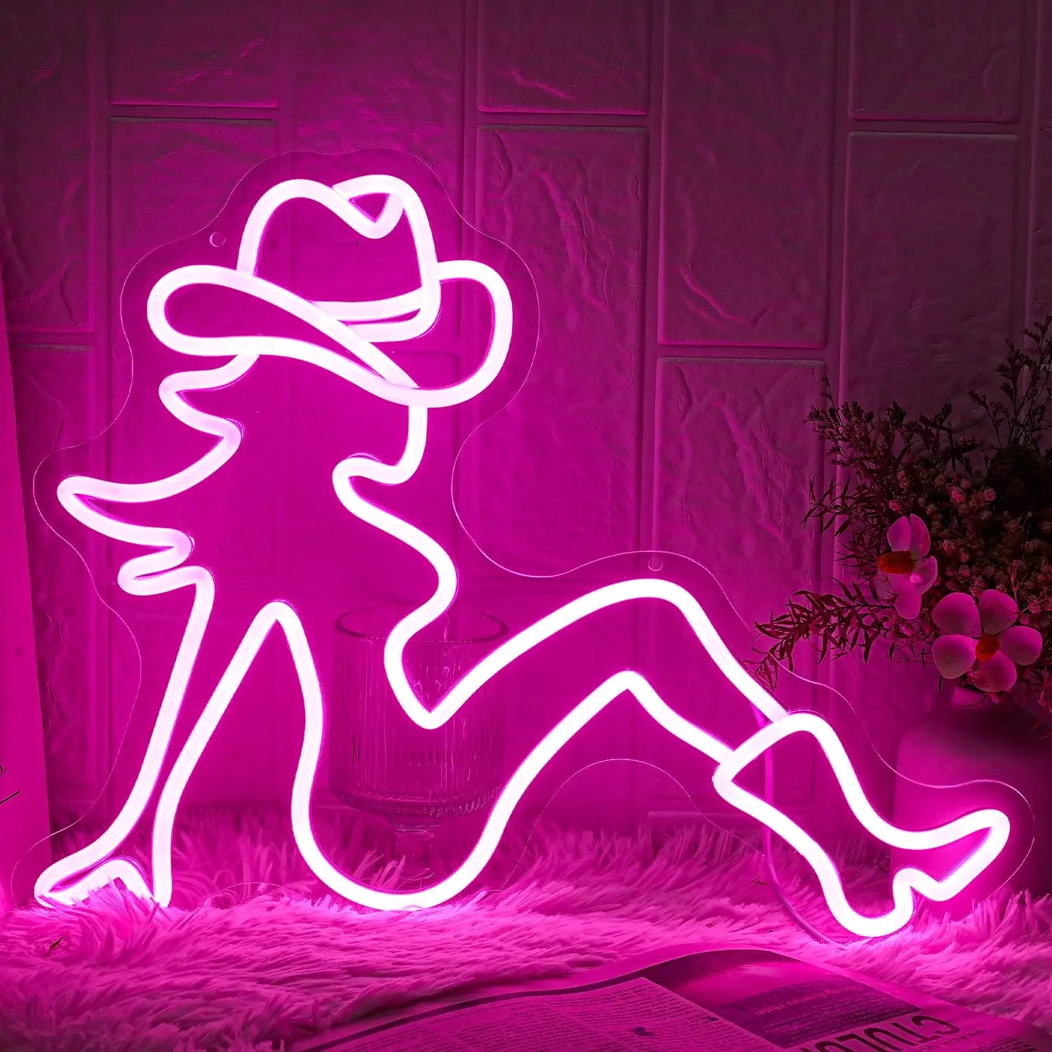 Cowgirl neon sign close-up showing vibrant pink glow with bold western silhouette design in dark ambient setting - wall setting
