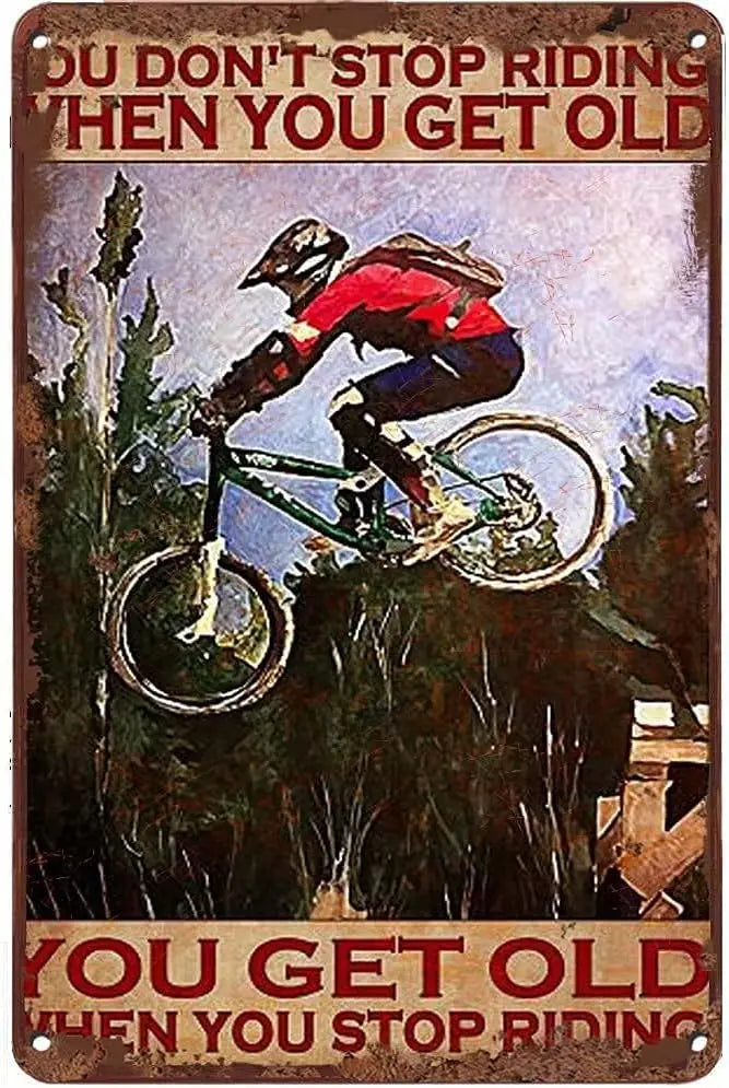 Mountain bike metal tin sign featuring motivational quote You Get Old When You Stop Riding with mountain biker silhouette against sunset background