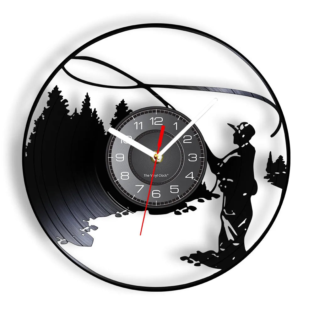 Fly fishing vinyl record wall clock featuring intricate laser-cut design with fly fisherman standing in water casting line with graceful arc overhead, surrounded by evergreen trees and mountain landscape on black vinyl record