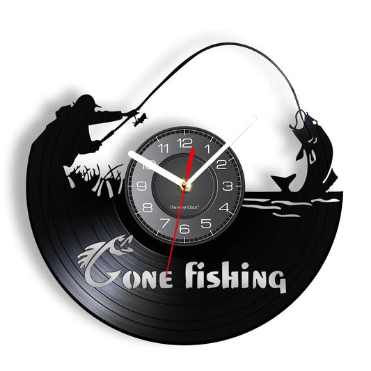 Gone Fishing vinyl record wall clock featuring intricate laser-cut design with two fishermen in boat, one casting line with arcing rod and one reeling in catch, with bold Gone Fishing text on black vinyl record