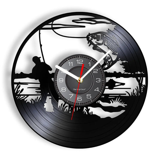 Fishing vinyl record wall clock featuring intricate laser-cut design with fisherman casting line from shore, cattails, water plants, and scenic lake backdrop with trees and mountains on black vinyl record
