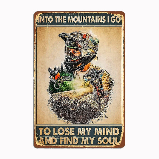 Into the Mountains I Go vintage metal tin sign featuring double-exposure design of mountain biker merged with mountain landscape and inspirational quote with classic distressed edges and sepia tones
